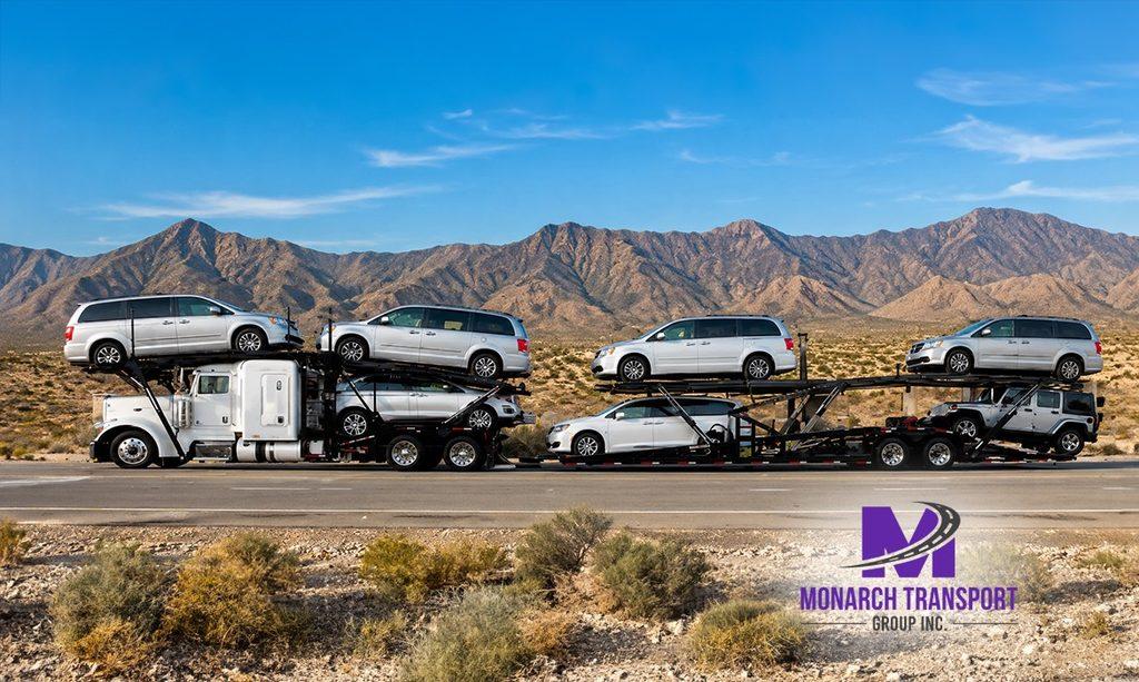 Open car carrier moving vehicles between California and Texas on a major interstate